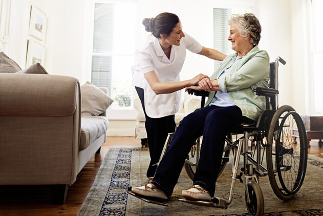 Older resident in a wheelchair talking with assisted care professional